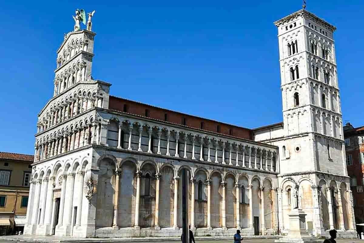 A church with a clock tower in the middle of a square.