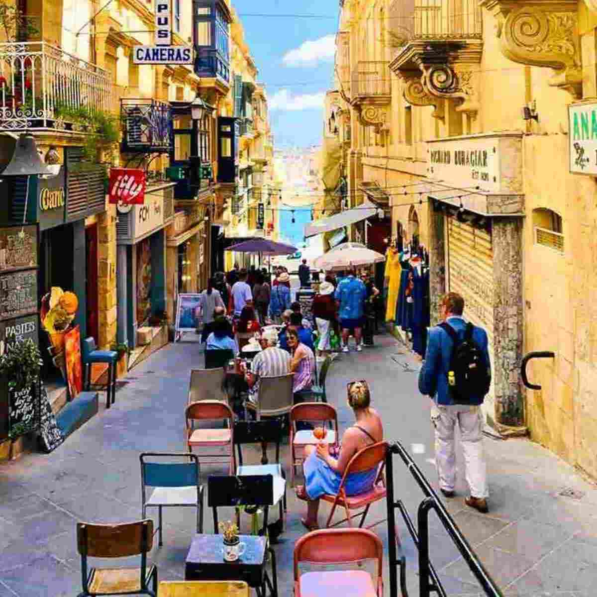 A narrow, bustling street with outdoor cafes.